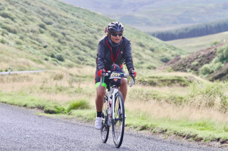 Kris riding her bike in a cycle-sportive, surrounded by countryside