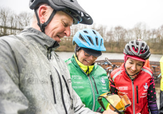 A rider, Breeze Champion and Guided Ride Leader looking at a phone